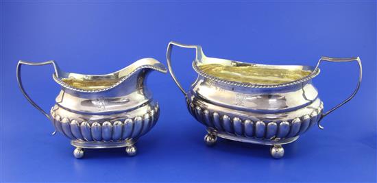 A George III demi-fluted silver oval sugar bowl and cream jug, 15.5 oz.